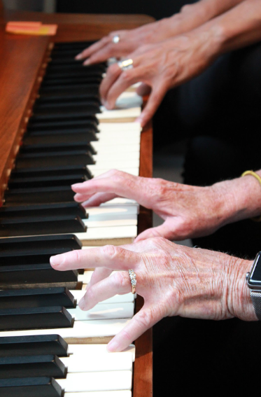 Harriett playing a piano duet with student during music lessons in Colorado Springs